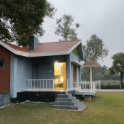 Private cottage at River Villa Resort Gazipur with open lawn and peaceful outdoor surroundings